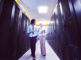 Two engineers working inside a data center.