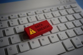 Close up image of computer keyboard and red wooden cube with text DATA BREACH