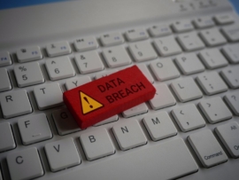 Close up image of computer keyboard and red wooden cube with text DATA BREACH
