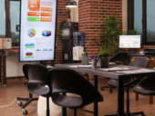 Vacant boardroom with presentation screen showing financial analytics charts and statistics for a company meeting.