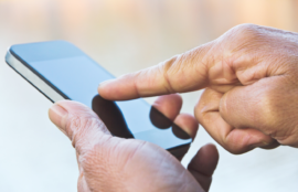 Person using their finger to scroll or type on a mobile device.