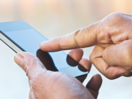 Person using their finger to scroll or type on a mobile device.