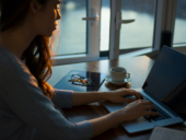 A woman working on her laptop on a coffee shop.