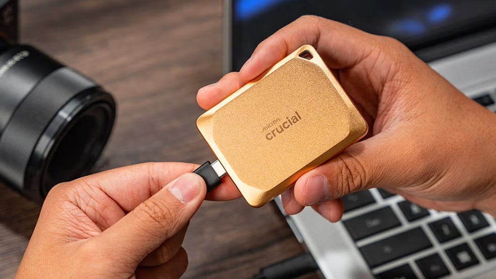 An SSD being connected to a USB type-C port to laptop.