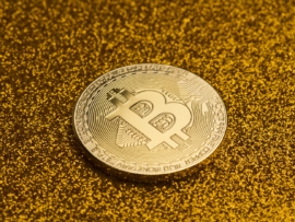 horizontal top view of single bitcoin coin on golden glittering background texture concept for rich