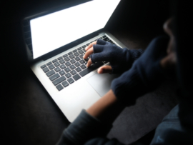 An unknown hacker using a MacBook.