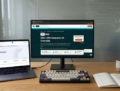 A laptop and desktop pc in a wooden table.