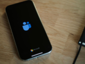 A smartphone displaying the blue Microsoft Teams logo and text on a black screen.