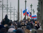 A group of people walking carrying flags