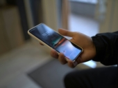 A person holding a smart phone in their hand.