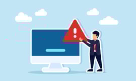 Businessman carrying a warning or exclamation sign beside a monitor.