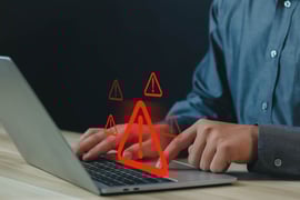 A person receiving a notification of security breach on his laptop.