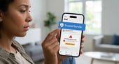 A woman holding her phone with a "Trusted Sender" verification on a software update.