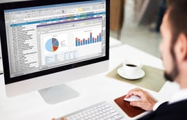 Business executive working on a digital marketing budget plan with a cup of coffee at a bright desk.